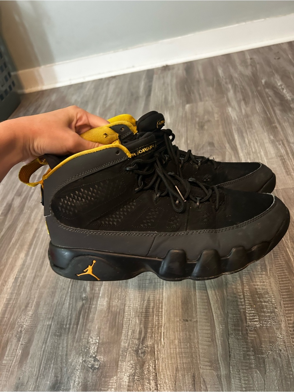 Men’s size 9.5 Jordan 9 Retro in black and University Gold.
